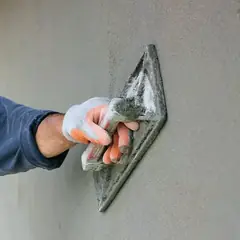 Duvarda mala ile perdah sıva yapan ustanın eli