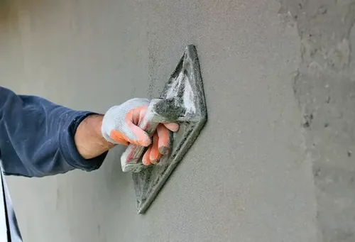 Duvarda mala ile perdah sıva yapan ustanın eli