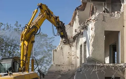 Ekskavatör kepçesiyle yıkılan eski betonarme bina