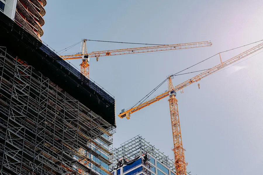 Yüksek katlı blokların arasında yükselen kule vinçler